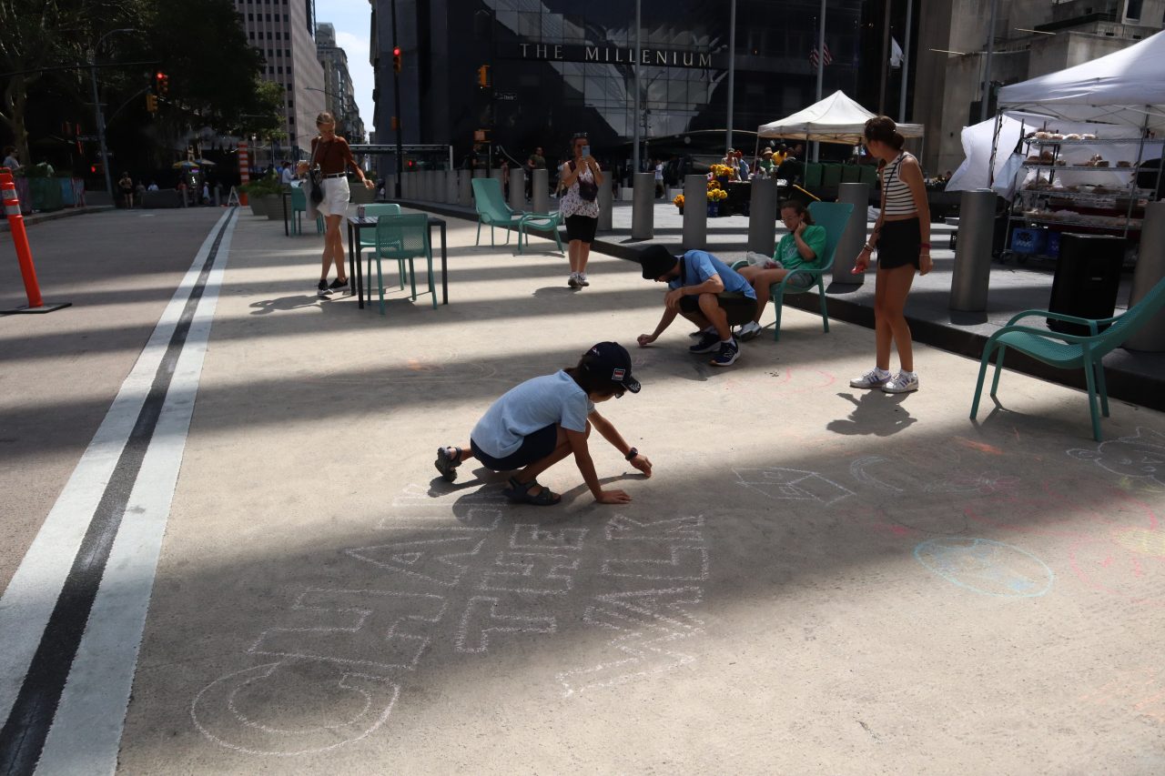 child drawing with chalk on street