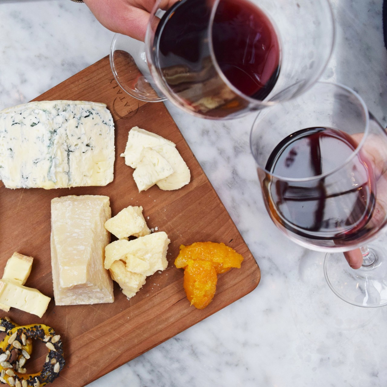Patrons clink wine glasses and enjoy a cheeseboard at Eataly World Trade Center